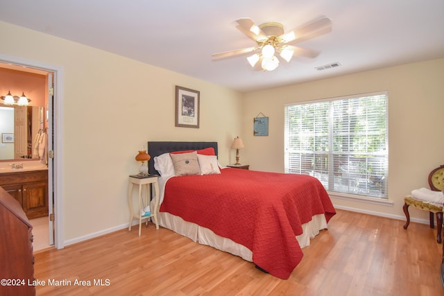 bedroom with light hardwood / wood-style floors, ensuite bath, ceiling fan, and sink