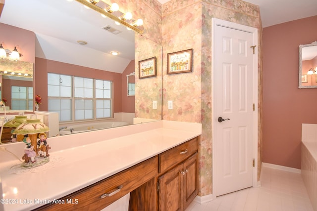 bathroom with tile patterned flooring, vanity, a bath, and vaulted ceiling