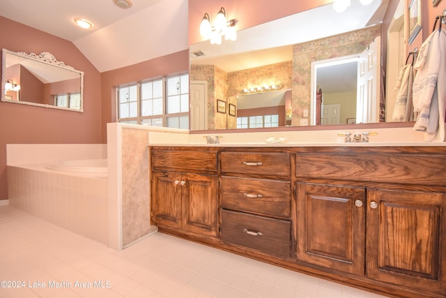 bathroom with tile patterned flooring, vanity, a relaxing tiled tub, and vaulted ceiling