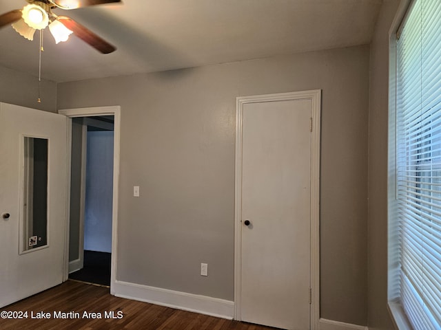 unfurnished bedroom with dark hardwood / wood-style flooring and ceiling fan