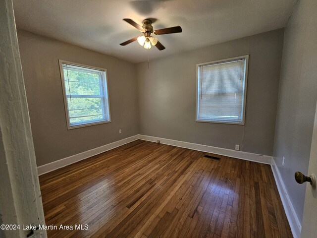 unfurnished room with dark hardwood / wood-style floors and ceiling fan