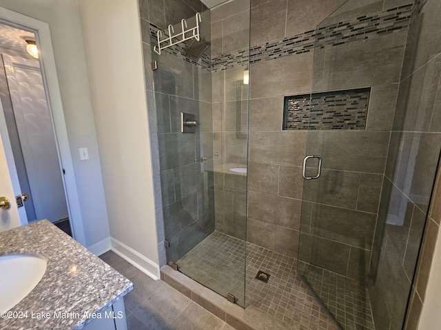 bathroom featuring tile patterned floors, vanity, and a shower with shower door