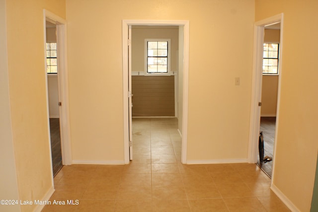 hallway featuring a healthy amount of sunlight and light tile patterned floors