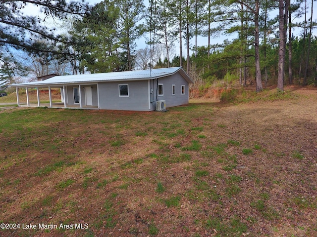 back of house with central AC and a yard