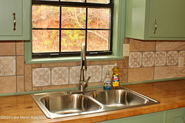 kitchen with butcher block counters, green cabinets, and sink