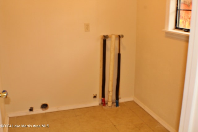 clothes washing area featuring tile patterned flooring and radiator heating unit