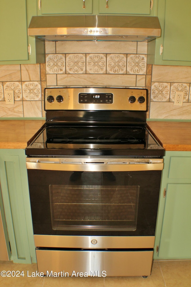 room details with stainless steel electric stove, green cabinets, and tasteful backsplash