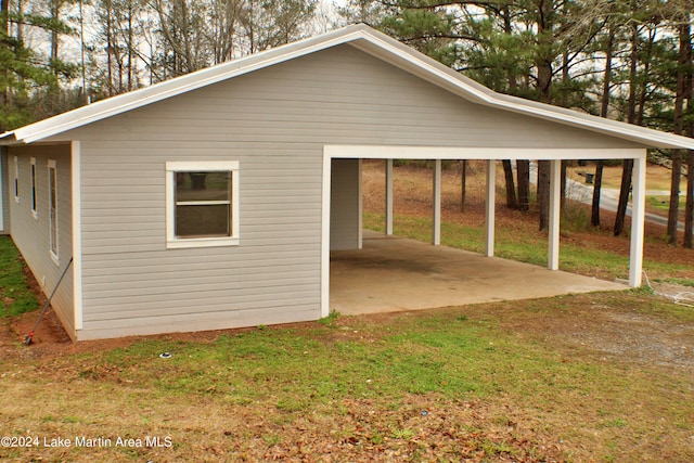 view of side of home featuring a yard and a carport