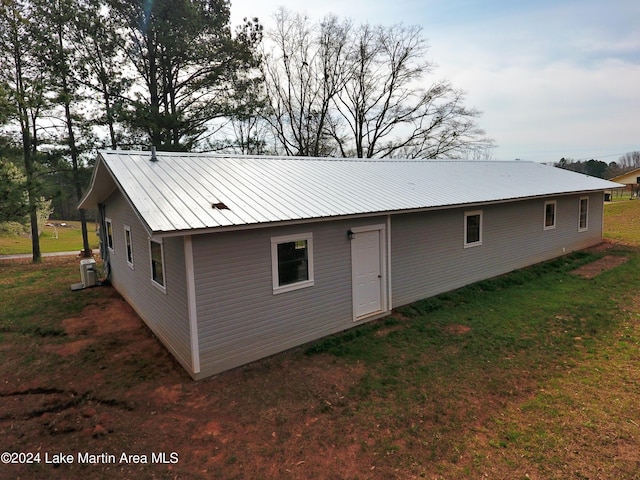 rear view of house featuring a yard and central AC