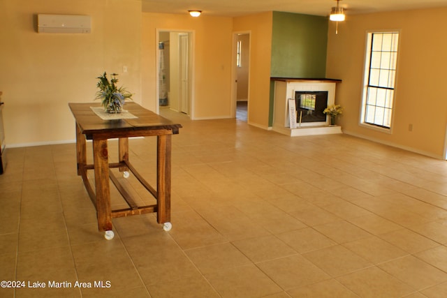 unfurnished living room featuring tile patterned flooring and a wall mounted air conditioner