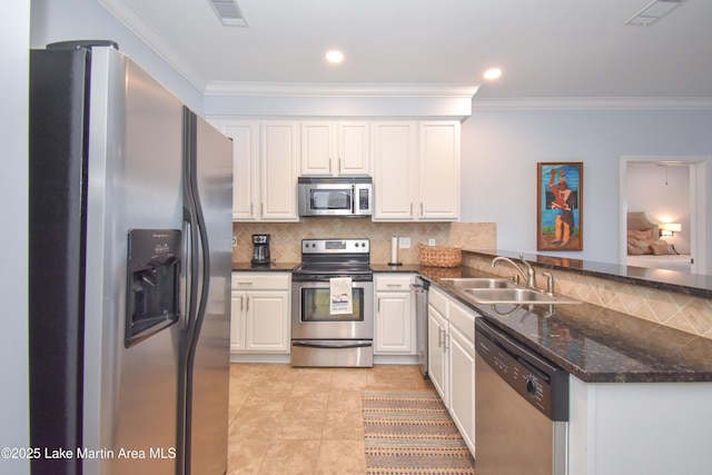 kitchen featuring stainless steel appliances, visible vents, white cabinetry, a sink, and a peninsula