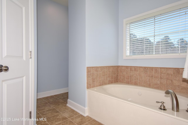 bathroom featuring a garden tub, tile patterned flooring, and baseboards