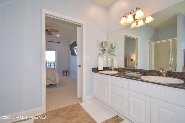 ensuite bathroom featuring baseboards, ensuite bath, a sink, and a shower stall