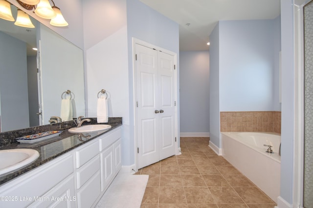 bathroom featuring tile patterned floors, a sink, a bath, and double vanity