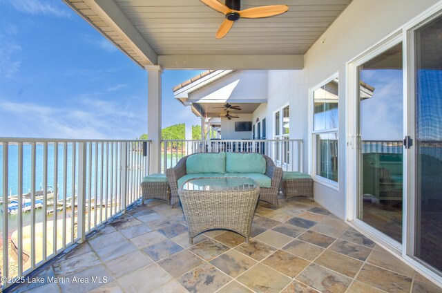 balcony featuring a ceiling fan and a water view