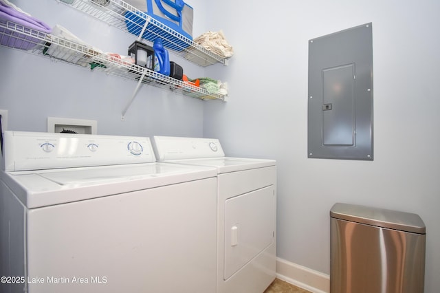 washroom featuring laundry area, electric panel, baseboards, and washing machine and clothes dryer