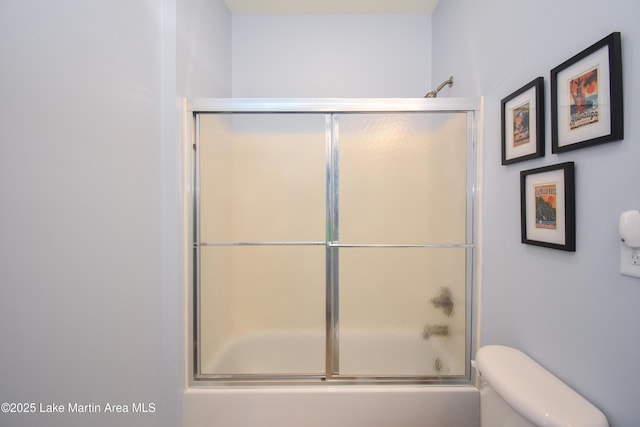 bathroom featuring shower / bath combination with glass door and toilet