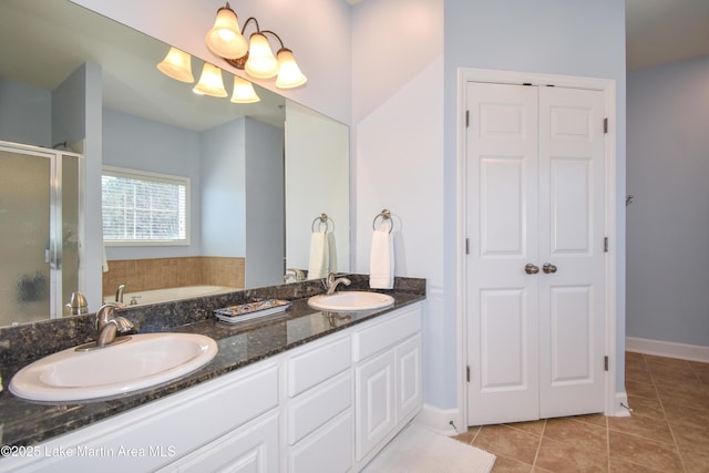 full bathroom featuring a closet, a stall shower, tile patterned flooring, and a sink