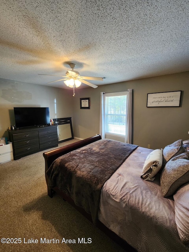 carpeted bedroom featuring ceiling fan and a textured ceiling