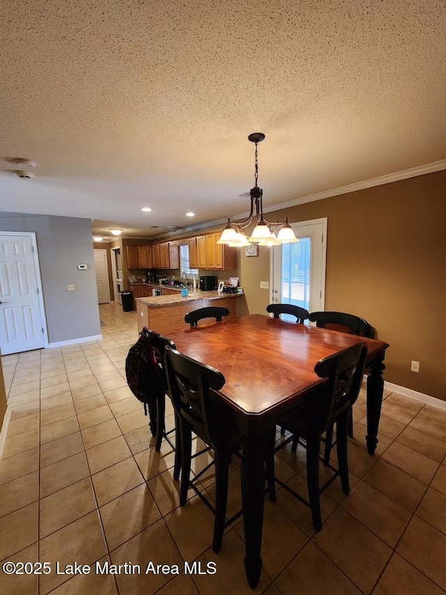 dining area featuring light tile patterned flooring, ornamental molding, and a textured ceiling