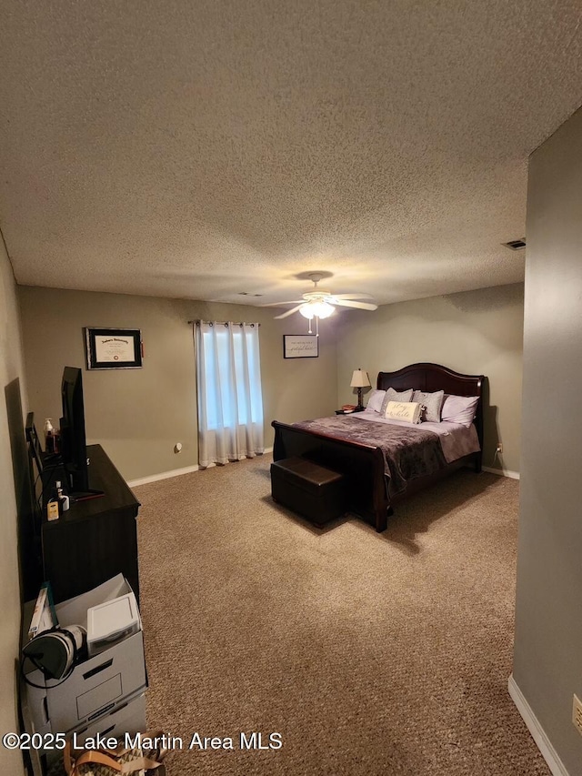 bedroom with ceiling fan, carpet, and a textured ceiling