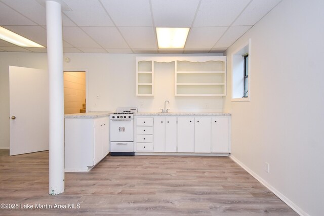 485 Ridgeview Dr, Alexander City, AL 35010 - kitchen featuring gas range gas stove, open shelves, light wood finished floors, a drop ceiling, and white cabinets
