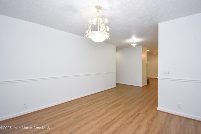 485 Ridgeview Dr, Alexander City, AL 35010 - spare room with wood finished floors, a textured ceiling, and a chandelier
