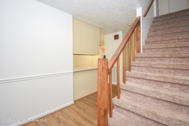 485 Ridgeview Dr, Alexander City, AL 35010 - staircase with wood finished floors and a textured ceiling