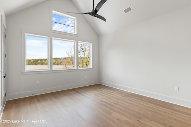 unfurnished room featuring a wealth of natural light, light wood-type flooring, visible vents, and a ceiling fan