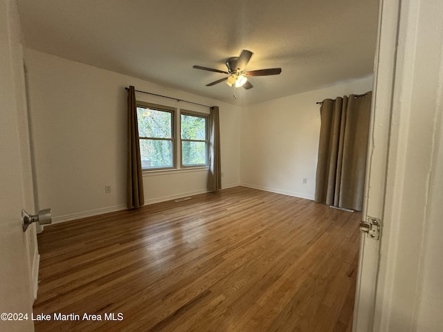 spare room with ceiling fan and wood-type flooring