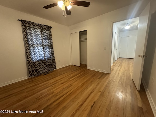 unfurnished bedroom with ceiling fan, a closet, and hardwood / wood-style flooring