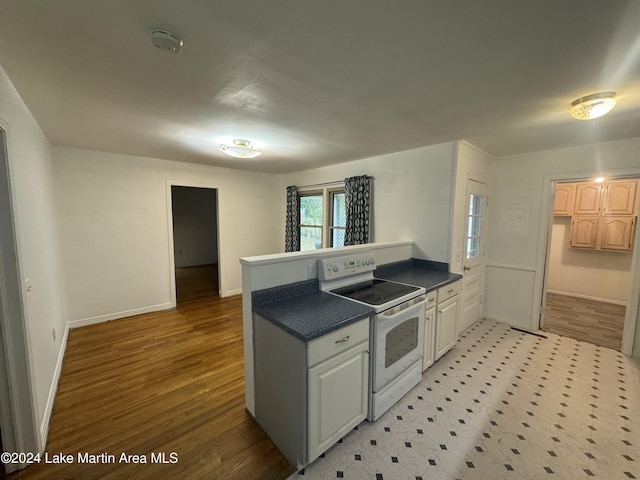 kitchen with kitchen peninsula, light hardwood / wood-style floors, white electric stove, and white cabinetry