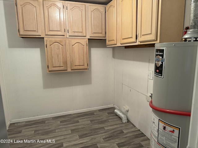 clothes washing area with cabinets, dark hardwood / wood-style flooring, and water heater