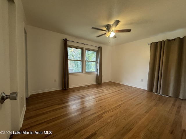 empty room featuring hardwood / wood-style flooring and ceiling fan