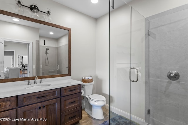 bathroom featuring vanity, toilet, and a shower with door