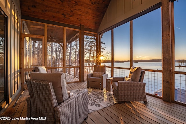 sunroom / solarium with a water view, vaulted ceiling, and ceiling fan