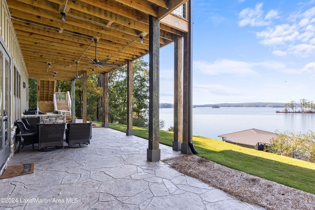 view of patio / terrace featuring a water view and ceiling fan