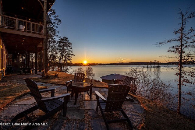 view of dock with a water view and a lawn