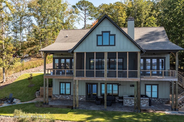 rear view of house with a patio, a sunroom, and a lawn