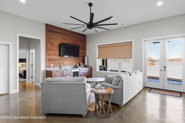 living room with french doors, wet bar, ceiling fan, beverage cooler, and wooden walls