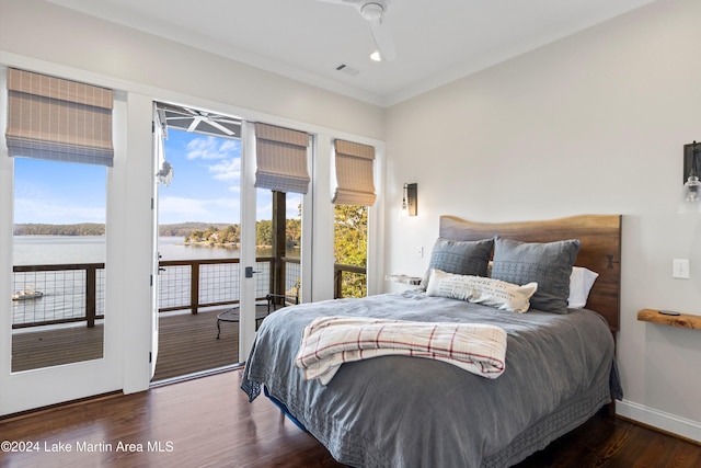 bedroom featuring a water view, dark hardwood / wood-style flooring, access to exterior, and crown molding