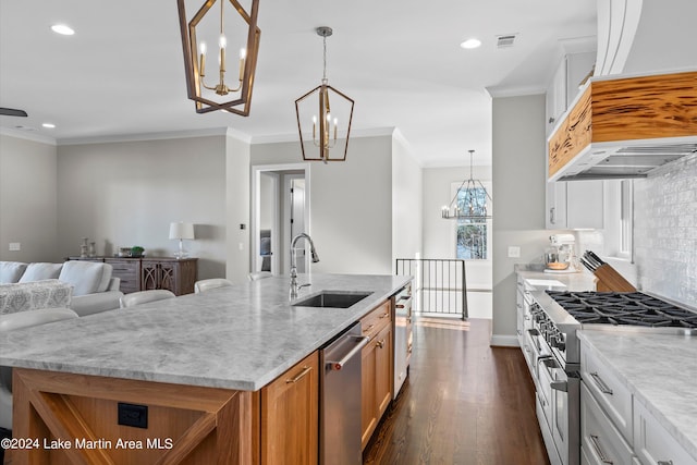 kitchen with an island with sink, stainless steel appliances, light stone counters, white cabinets, and pendant lighting