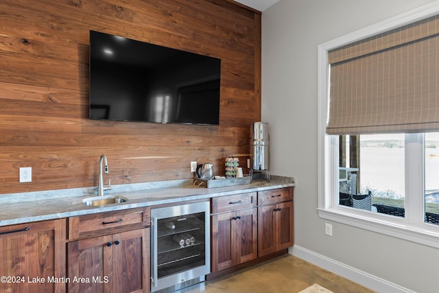 bar with sink, wood walls, and wine cooler