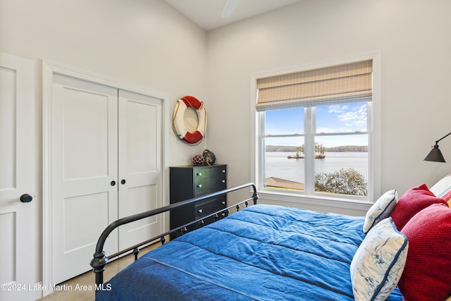 bedroom with a water view and a closet