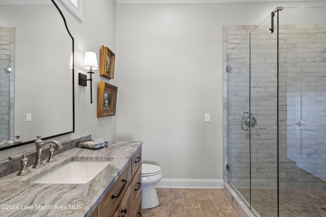 bathroom with vanity, toilet, and a shower with shower door