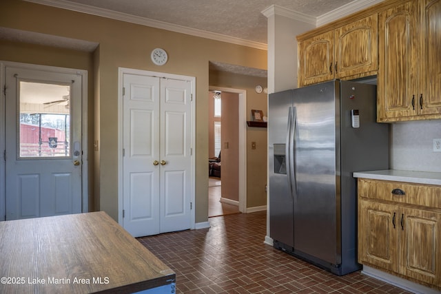 kitchen with butcher block countertops, stainless steel fridge with ice dispenser, crown molding, and a textured ceiling