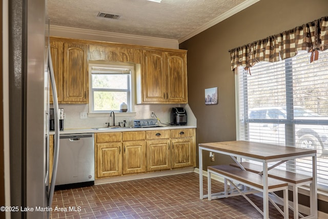 kitchen featuring a textured ceiling, appliances with stainless steel finishes, decorative backsplash, and sink