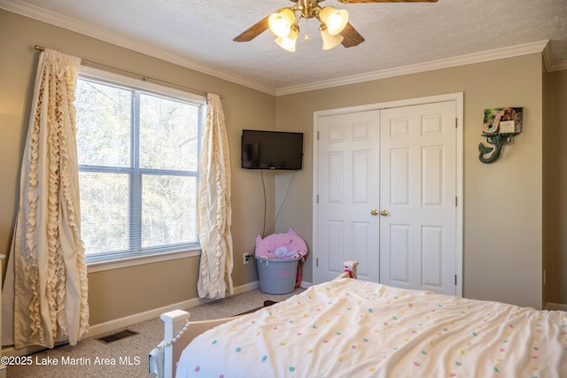 bedroom with ceiling fan, a closet, crown molding, and a textured ceiling