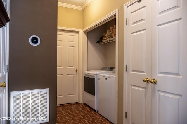 laundry area featuring washer and clothes dryer and ornamental molding