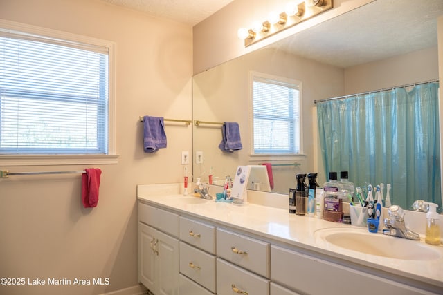 bathroom featuring a textured ceiling, a wealth of natural light, and vanity